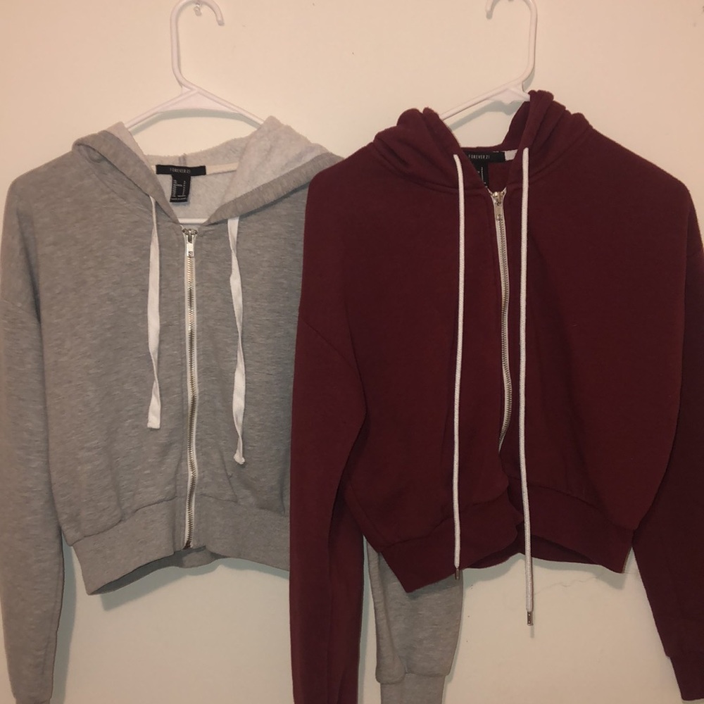 Two cropped zip up hoodies